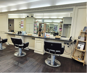 Intérieur d'un salon de coiffure moderne avec trois chaises et un grand miroir mural. au Mans dans la Sarthe 72