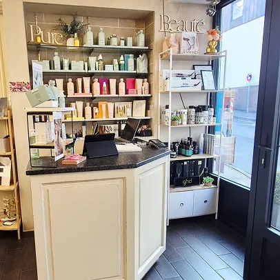 Comptoir de réception dans un salon de beauté avec produits cosmétiques exposés.