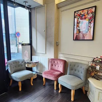 Trois chaises rembourrées dans une salle d'attente avec tableau fleuri.